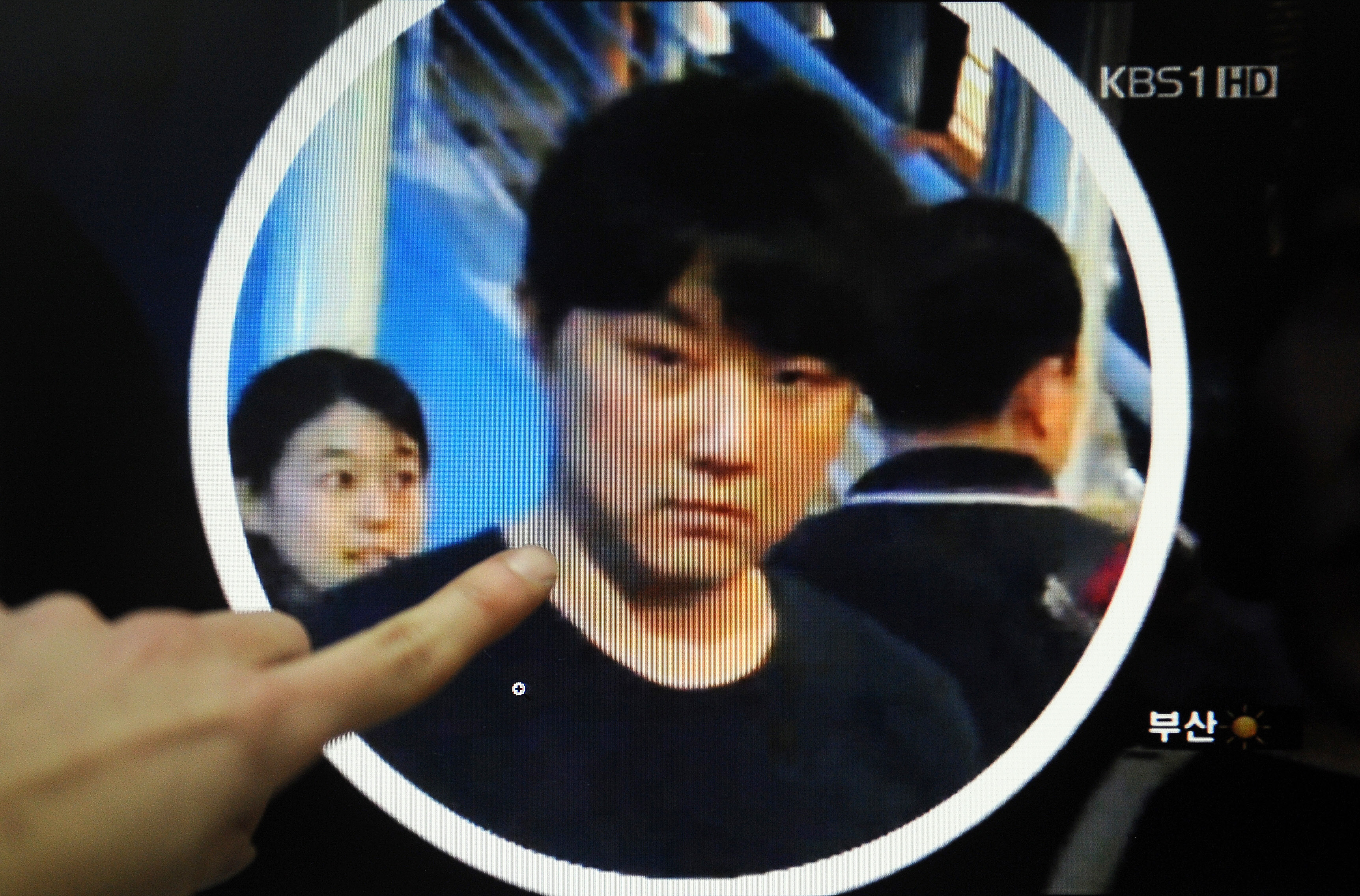 A man points at a computer screen in Seoul on February 16, 2011 showing a man believed to be North Korean leader's second son, Kim Jong-Chol, as he enters a concert for British guitarist Eric Clapton in Singapore on February 14, 2011. (Park Ji-Hwan/AFP/Getty Images)