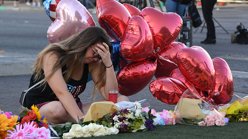 Destiny Alvers who attended the Route 91 country music festival and helped rescue her friend who was shot, reacts at a makeshift memorial on the Las Vegas Strip in Las Vegas, Nevada on October 3, 2017. (Mark Ralston/AFP/Getty Images)