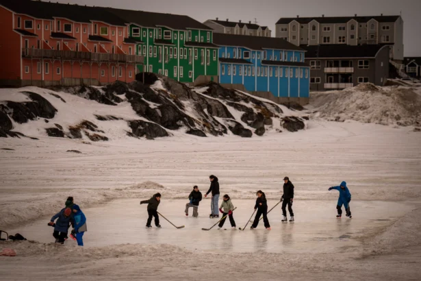 People play on an icy surface in Nuuk, Greenland, on Feb. 16, 2025. (AP Photo/Emilio Morenatti)