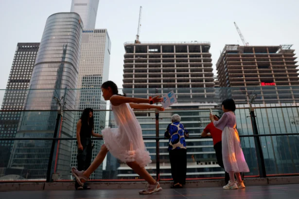 People visit a terrace of a shopping mall overlooking the central business district (CBD) in Beijing on Aug. 11, 2025. (Tingshu Wang/Reuters)
