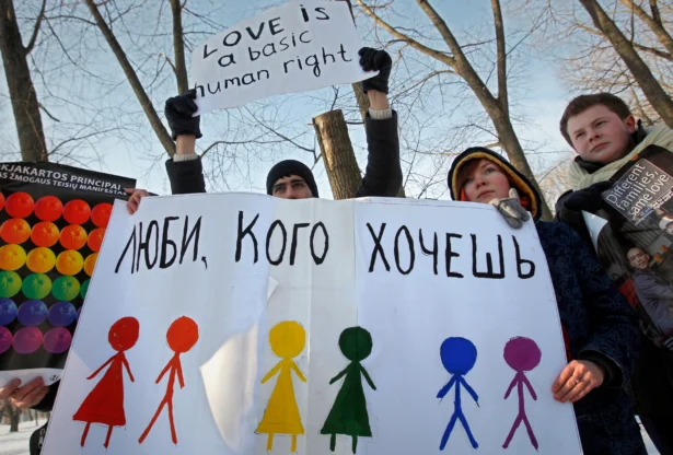Activists hold placards during a protest in front of the Department of Justice in Minsk, Belarus, on Feb. 14, 2010. The sign on the placard reads, "Love who you want." (AP Photo, File)