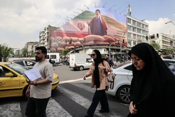 Iranians walk past a large billboard depicting Iranian leader Ayatollah Mojtaba Khamenei on a street in Tehran on April 20, 2026. (Atta Kenare/AFP via Getty Images)