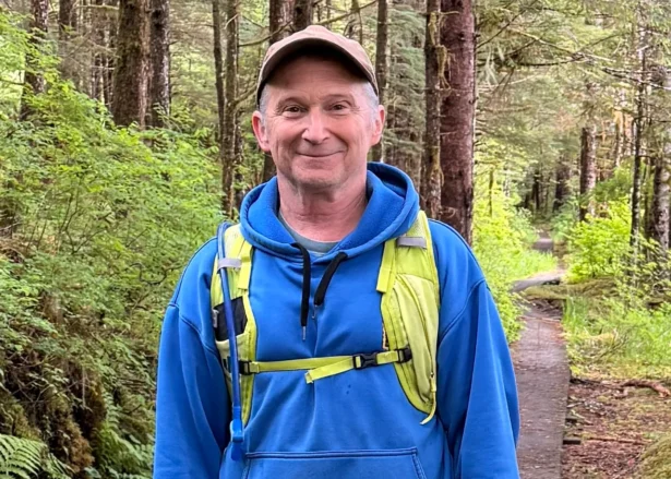 In this image provided by Karen Dillman, Alaska Senate candidate Dan Sullivan, one of the challengers to the incumbent senator, also named Dan Sullivan, poses for a photo on a hike on Kupreanof Island, near Petersburg, Alaska, on June 7, 2026. (Karen Dillman via AP)