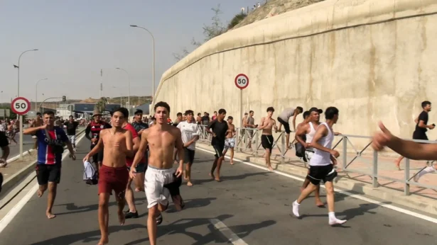 Immigrants run and cheer as they cross on foot into the Spanish North African enclave of Ceuta from Morocco, after swimming over from the Moroccan side and overwhelming police at the city's breakwater, according to Spain's Guardia Civil, in Ceuta, Spain, July 30, 2026, in this screenshot obtained from a handout video. (Faro TV via Reuters)